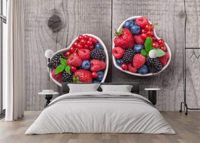 Berries overhead mix with leaves colorful closeup assorted in two heart shaped ceramic jars. Raspberry, blueberry, red currant, strawberry on rustic wooden table in studio. Wall mural