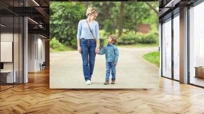 young mother and her cute little son walking in a park Wall mural