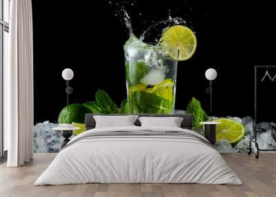 Mojito, a cool cocktail of lime and mint and soda, in a highball glass with a splash and ice, isolated on a black background Wall mural