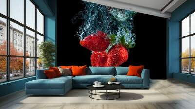 Red strawberry dropped into the water with splash on a black background Wall mural