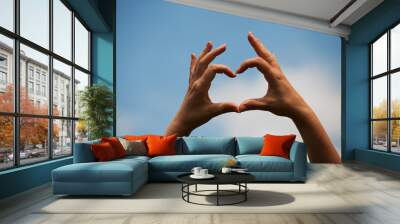 Love heart made with hands on blue sky Wall mural