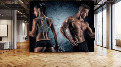 athletic man and woman with a dumbells. Wall mural