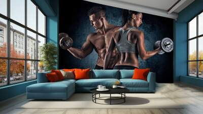 Athletic man and woman with a dumbells. Wall mural