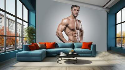 muscular athlete bodybuilder man on a gray background Wall mural