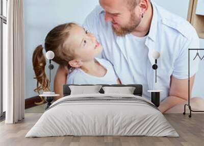 Adorable little girl in white dress hugging loving father Wall mural