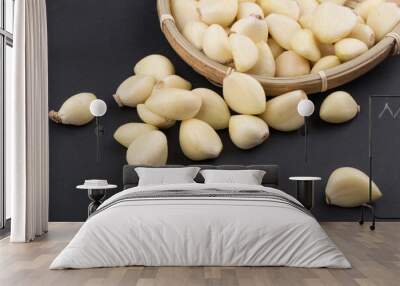 Pile of peeled garlics on black background isolated. Wall mural