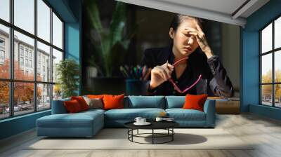 A businesswoman has a headache or eye-strain after having overworked. Wall mural