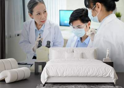 A professional Asian senior female medical specialist training two young junior medical specialist Wall mural