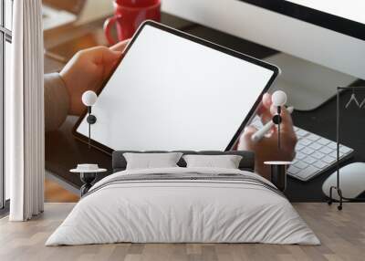 Businessman using tablet computer at office workspace. Wall mural