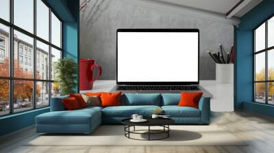 Close up view of workspace with blank screen laptop, office supplies and red coffee cup on white table with grey loft wall Wall mural