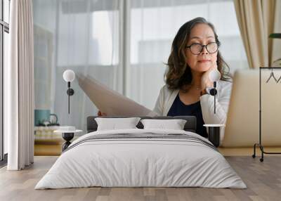 Concentrated asian middle aged female businesswoman using portable computer Wall mural