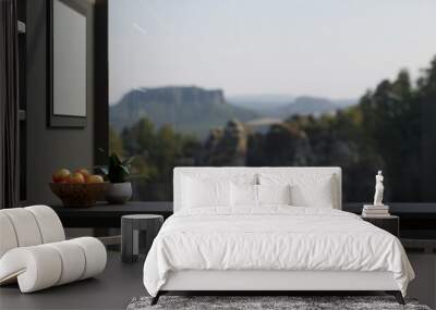 Copy space on modern black dining table, stools over blurred green forrest view in background Wall mural