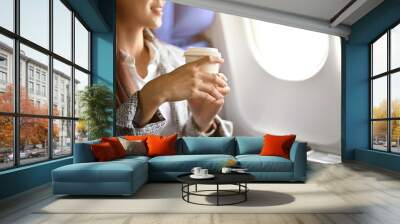 Cropped, A successful asian businesswoman sipping a hot coffee during the flight Wall mural