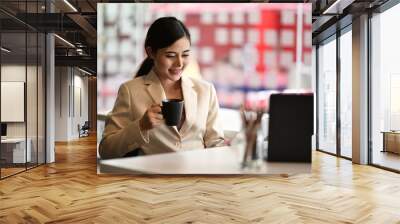 Cropped shot of a young businesswoman sitting at her desk in an office reading report on tablet Wall mural