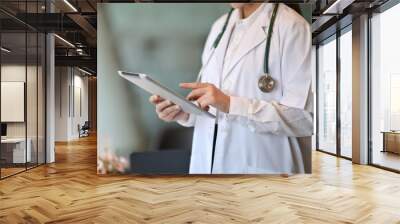 Cropped shot of doctor using a digital tablet in a hospital Wall mural