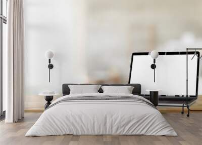 Cropped shot of open blank screen laptop computer on wooden table and copy space with blurred office Wall mural