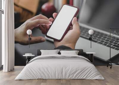 Cropped shot of young professional businessman working on his project while using smartphone in dark modern office Wall mural