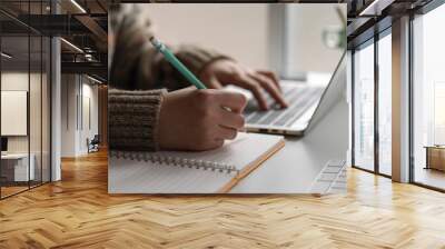 Female university student online learning with laptop and stationery on worktable at home Wall mural