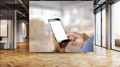 Man using Smartphone with blurred office background. Wall mural