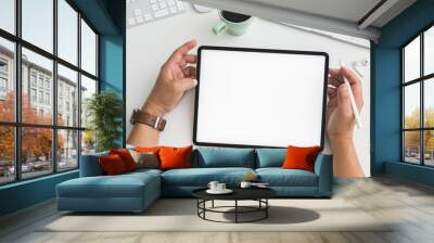 Overhead shot of Businessman working on tablet in workspace with computer, laptop and other office supplies Wall mural