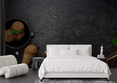 Overhead shot of summer dessert with chocolate flavour ice-cream cones on dark table background Wall mural