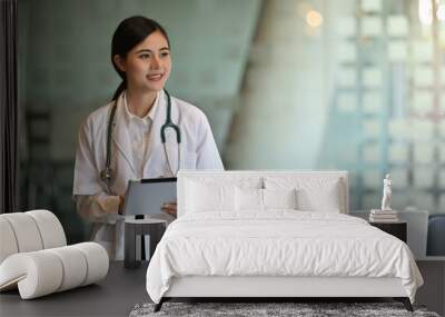 Portrait of a Asian doctor using a digital tablet in a hospital Wall mural