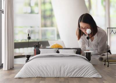 Portrait of young Asian female architect working on project in site office Wall mural