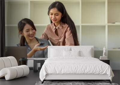 Portraits of two businesswoman consulting on their work with office supplies in office room Wall mural