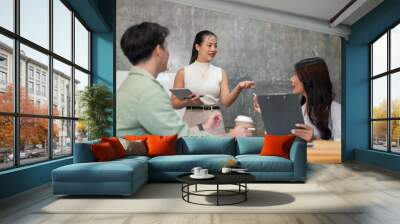 Professional, confident Asian businesswoman is leading the meeting and speaking to her team members. Wall mural