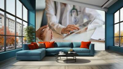 shot of a doctor showing a patient some information on a digital tablet Wall mural