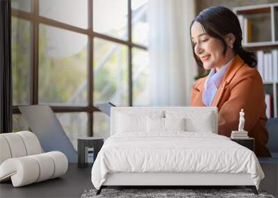 side view of Asian businesswoman using her tablet to check her meeting schedule Wall mural