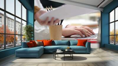 Side view of two businesswoman working together on white table in modern meeting room Wall mural