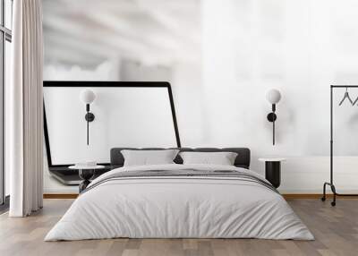 Simple workspace with laptop and plant pot on white desk in blurred background Wall mural