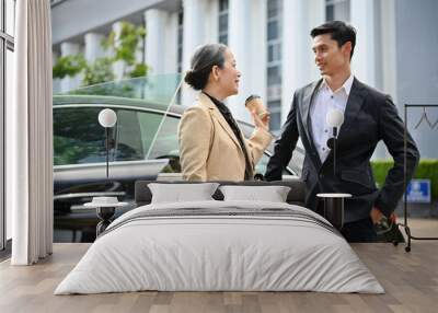 Successful Aged asian businesswoman and professional businessman standing in front the car. Wall mural