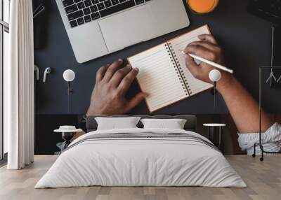 Top view of man working on his project while writing his ideas on note Wall mural