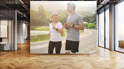 Two asian sporty aged woman and millennial male running or jogging together. Wall mural