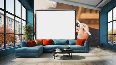 Young male freelancer holding blank screen tablet Wall mural