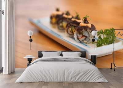 Sushi roll with crab, avocado, and herbs, drizzled with sauce and topped with roe. Wall mural