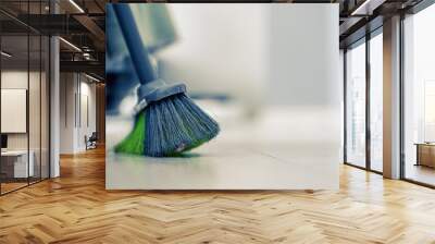 Big broom for wooden floor cleaning standing in light room at home or office building indoor closeup. Cleanup service conception. Wall mural