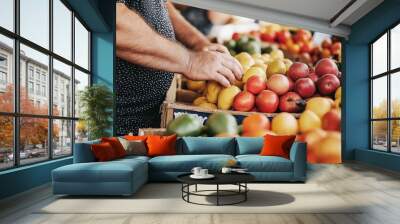 Man Hand Holding Fresh Lemon in Front of Vibrant Bin of Lemons and Apples at Farmers Market Wall mural