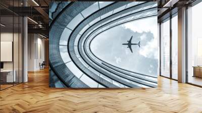 Low angle modern architecture building with landing airplane  Wall mural