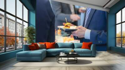 catering buffet food indoor in luxury restaurant with meat and vegetables - Close-up of the hands of a man and a woman holding a plate of food Wall mural