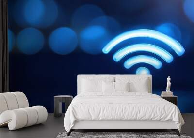 Blue Wi-Fi symbol glowing with blurred bokeh background, representing wireless internet connection and digital connectivity. Wall mural