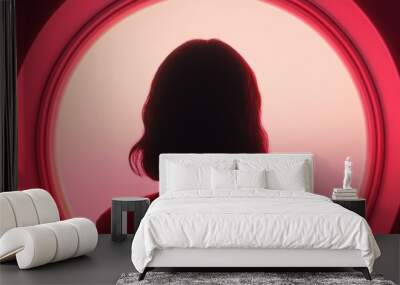 Silhouette of a woman against a vibrant circular light, creating a dramatic and mysterious atmosphere in red tones. Wall mural