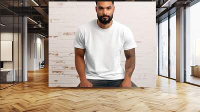 A man with a beard sits on a chair in a white T-shirt. Wall mural