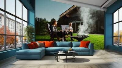 Couple couple sits on the lawn at home and communicates Wall mural