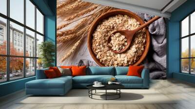 top view rolled oats or oat flakes in bowl with wooden spoon background Wall mural