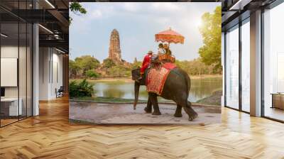 Tourists on an ride elephant tour of the ancient city in background Wall mural