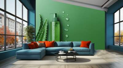 A bottle of aloe vera lotion is sitting on a green surface with droplets of wate Wall mural