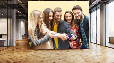 Young people using smartphones - Group of social media co workers having fun and takeing a selfie - Obsessed with online and shareing lifestyle moments -  Technology concept Wall mural